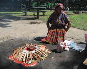 Индианка зажигает костёр и сжигает ароматические палочки и специи в Археологическом парке Каминальхуйю. Так эхом отдаются майяские культы